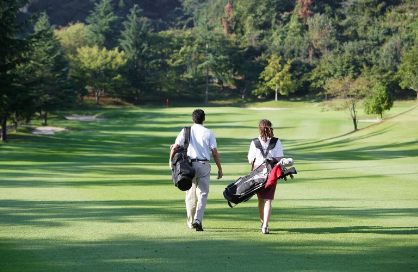 Two friends walking a golf course fairway with their bags