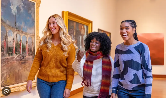 Three friends laughing together at an art museum