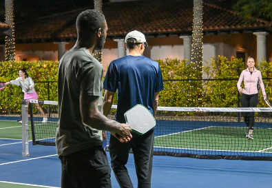 Two friends walking onto a pickleball court to play doubles